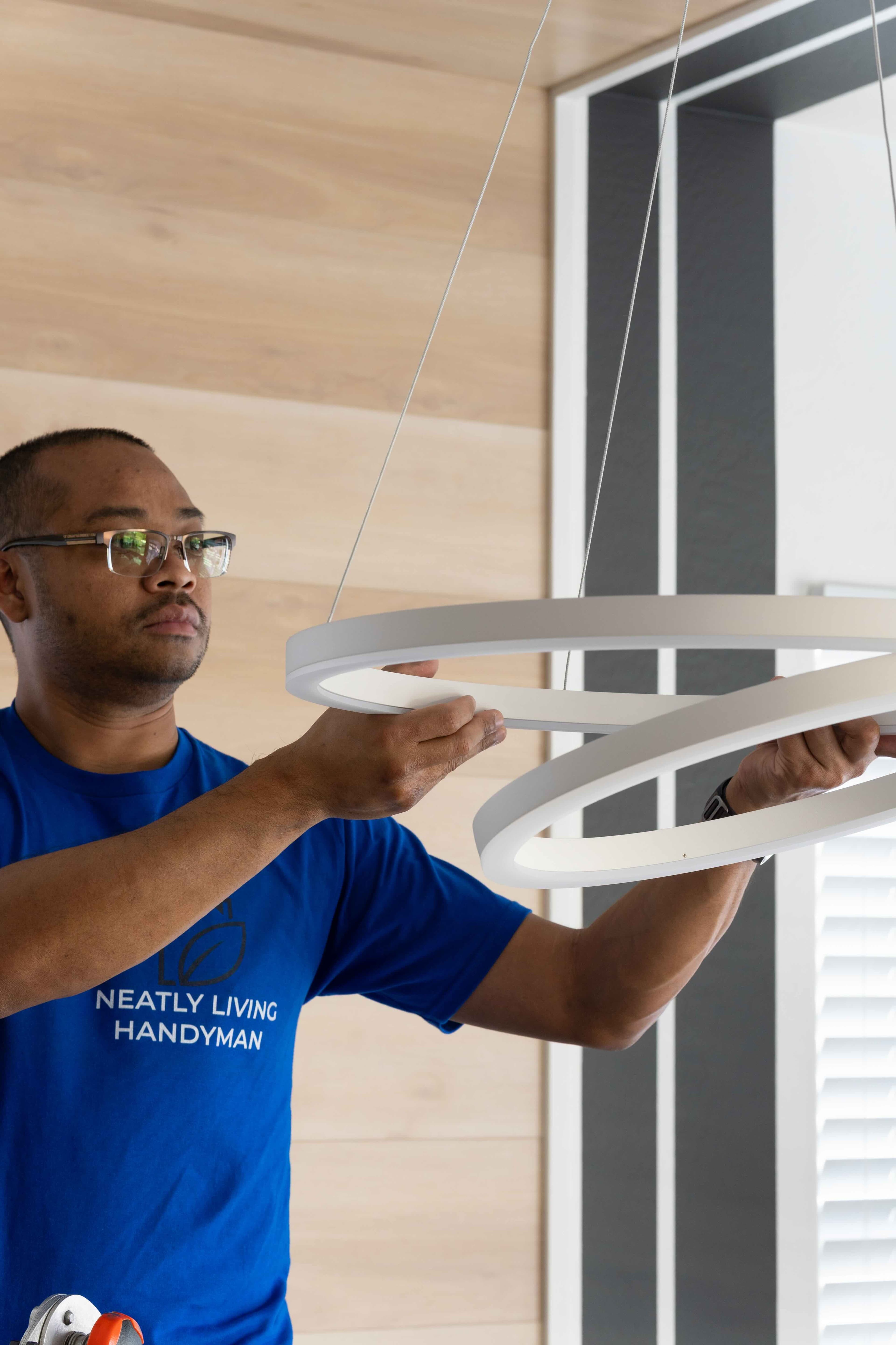 Neatly Living Handyman installing a modern circular light fixture